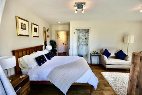 a bedroom with a large bed and a couch at The Paddock at Peacock Farm near Belvoir Castle in Redmile