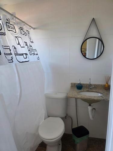 a white bathroom with a toilet and a sink at Pousada Sol Radiante in São Pedro da Aldeia