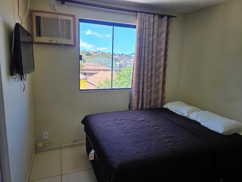 a small bedroom with a bed and a window at Pousada Sol Radiante in São Pedro da Aldeia