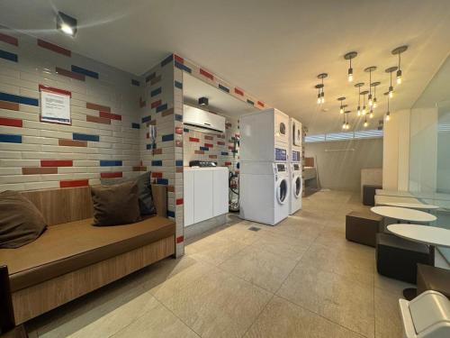 a room with a kitchen with a refrigerator and a couch at Studio aconchegante in Belo Horizonte