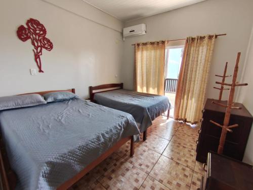 a bedroom with two beds and a dresser in it at Sobrado Itapoá in Itapoa
