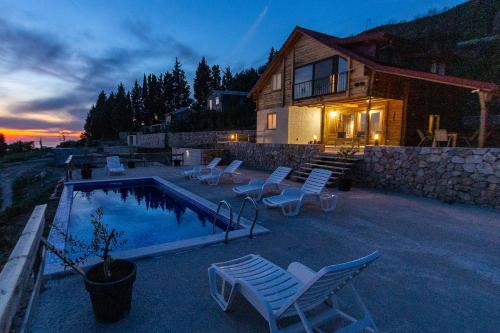 a house with a pool and chairs and a building at Olive Panorama Villa in Dobra Voda