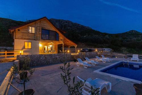 a house with a swimming pool next to a house at Olive Panorama Villa in Dobra Voda