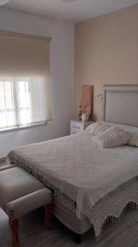 a bedroom with a white bed and a window at La casita de Susi in San Pedro