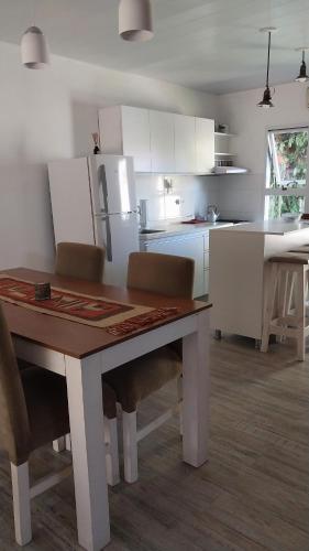 a kitchen with a table with chairs and a refrigerator at La casita de Susi in San Pedro