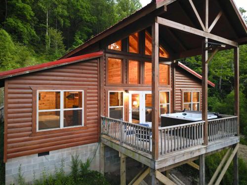 a log cabin with a hot tub on a deck at Just Right- RRG -Relaxing - Secluded in Slade
