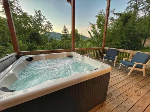 a hot tub on a deck with two chairs at Just Right- RRG -Relaxing - Secluded in Slade