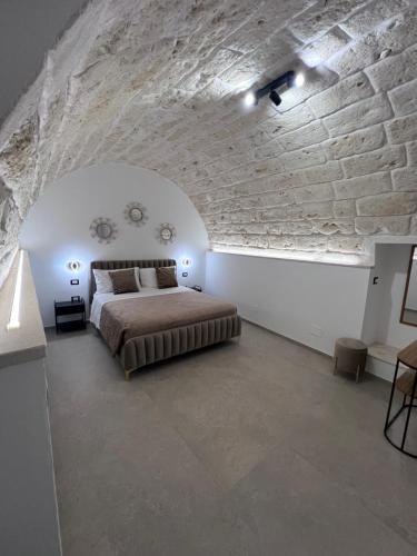 a bedroom with a bed and a stone wall at Buonaventura house2 in Triggiano