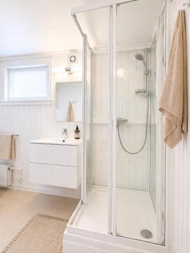 a white bathroom with a shower and a sink at Nordic Studio - Gravdal, Lofoten in Haug