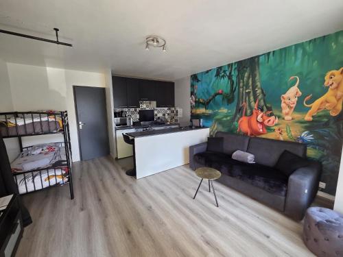 a living room with a couch and a kitchen at Studio à 2 pas de Disneyland in Esbly