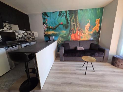 a living room with a couch and a table in a kitchen at Studio à 2 pas de Disneyland in Esbly