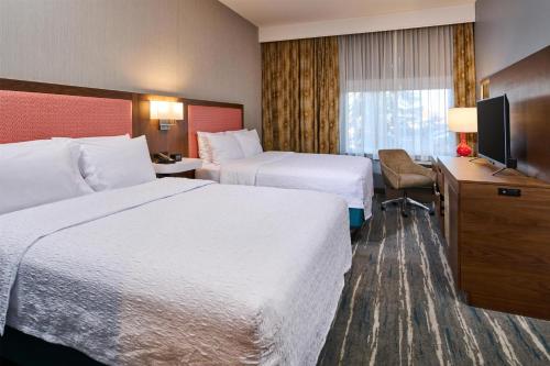 a hotel room with two beds and a television at Hampton Inn Anchorage in Anchorage