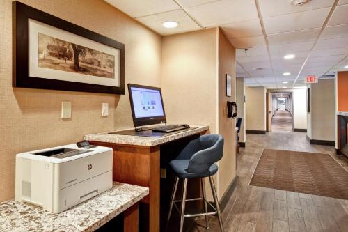 an office with a computer on a desk with a chair at Hampton Inn Auburn in Auburn