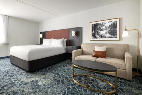 a hotel room with a bed and a couch at Doubletree By Hilton Concord Downtown in Concord