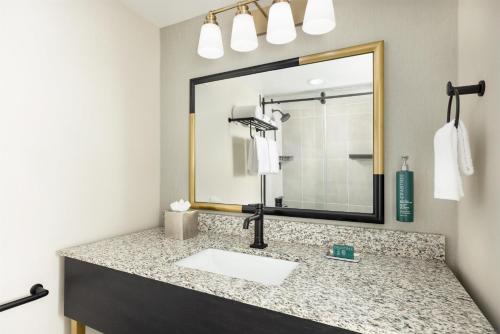 a bathroom with a sink and a mirror at Doubletree By Hilton Concord Downtown in Concord