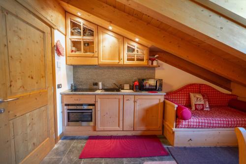 a kitchen with a red couch in the attic at Chalet Adda - Appartamento mansarda con garage privato in Bormio