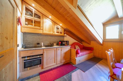 a kitchen with a sink and a couch in a room at Chalet Adda - Appartamento mansarda con garage privato in Bormio