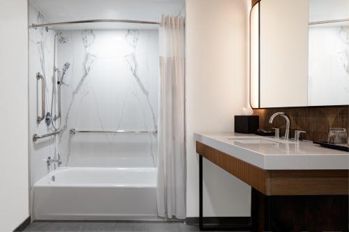 a bathroom with a white tub and a sink at Renaissance Tulsa Hotel & Convention Center in Union