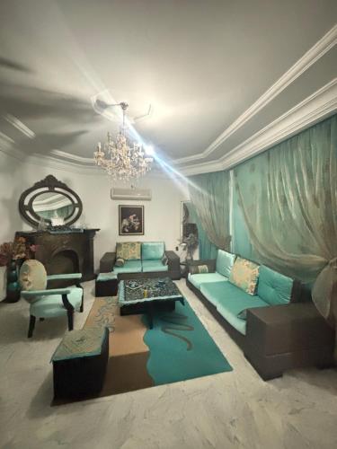a living room with a couch and a chandelier at Maison du prince in Yasmine