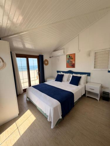 a bedroom with a large bed with blue and white sheets at Üzüm İskelesi in Ahmetçe