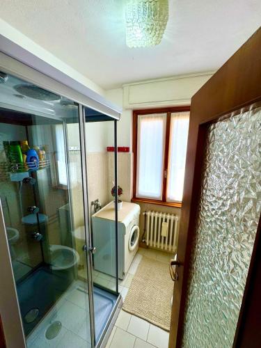 a bathroom with a shower and a glass shower backdoor at Casa Aurea Lake Como Apartment in Esino Lario