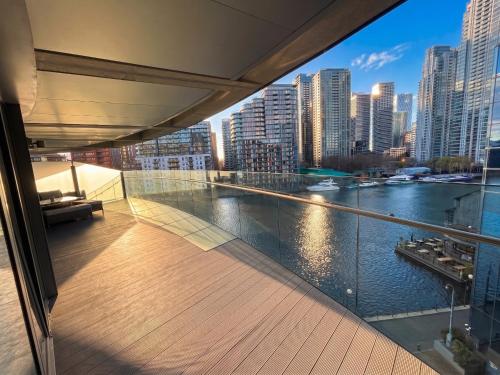 a balcony with a view of a river and buildings at London Canary Wharf Luxury Stay in London