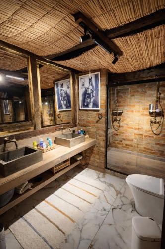 a bathroom with two sinks and a toilet at Cabana do Retiro Refúgio Rústico na Natureza! in Alto da Conceição