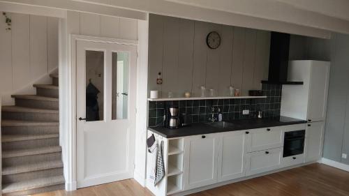 a kitchen with a sink and a staircase at Ruime Vakantiewoning - Hoeve Niets meer - met eigen privé terras en tuin in Balkbrug