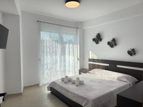 a bedroom with a bed and a window with butterflies on the wall at Iliana Apartment in Afantou