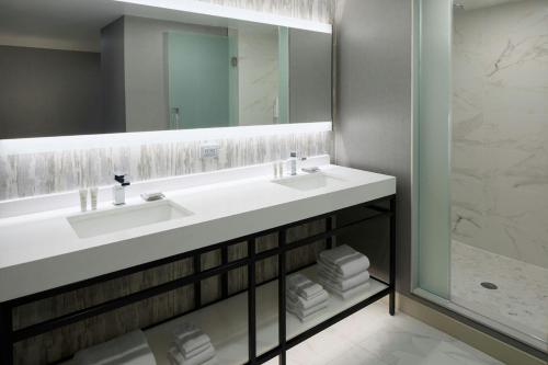ein Badezimmer mit einem weißen Waschbecken und einem Spiegel in der Unterkunft Ottawa Marriott Hotel in Ottawa