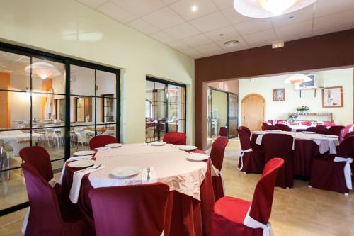 a dining room with tables and red chairs at Camping la Sierrecilla in Humilladero