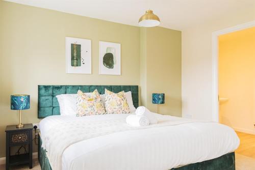 a bedroom with a large bed with white sheets at 4 Bedroom House in Shrewsbury in Shrewsbury