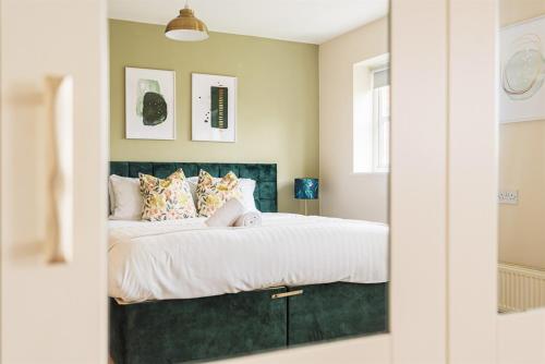 a bedroom with a large bed with a green headboard at 4 Bedroom House in Shrewsbury in Shrewsbury