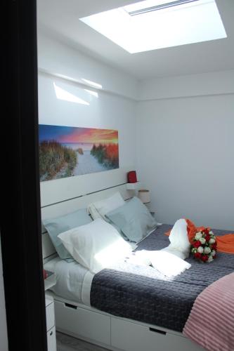 a bedroom with a bed with a painting on the wall at Alojamentos Céu Azul in Fernao Ferro
