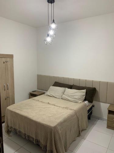 a bedroom with a bed and a light fixture at Praia do Frances-Riviera do Frances casa 37 in Marechal Deodoro