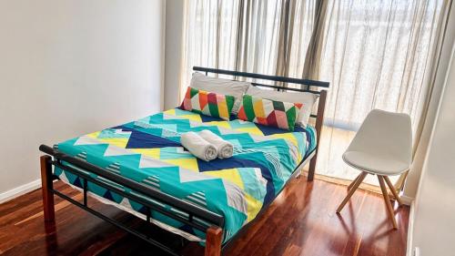 a bedroom with a bed and a chair and a window at Wagon Holiday Home in Broadwater