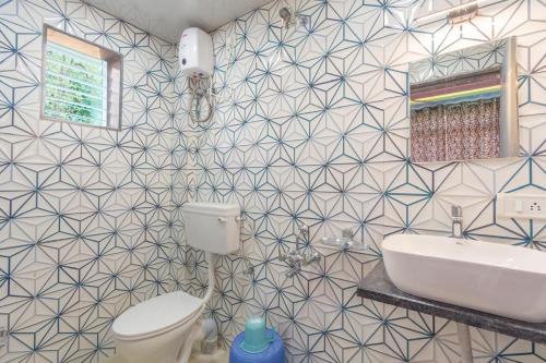 a bathroom with a toilet and a sink and a mirror at Jalsa Bungalow in Malavli