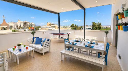 a patio with a table and chairs and a balcony at City Penthouse in Larnaca