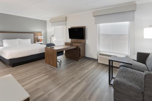 a hotel room with a bed and a desk with a television at Hampton Inn & Suites Lanett/West Point in Lanett