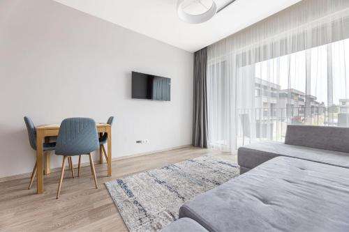 a bedroom with a bed and a table and a desk at Baltic Cozy Spot in Palanga