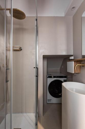 a kitchen with a washing machine and a glass shower at EOS Gaeta in Gaeta