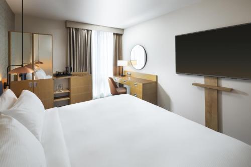 a hotel room with a bed and a flat screen tv at Hilton Garden Inn Bristol City Centre in Bristol
