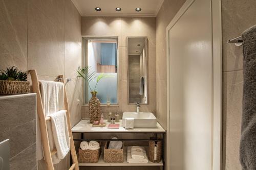 a bathroom with a sink and a mirror at Ninemia Shore Retreat in Stalis in Stalís