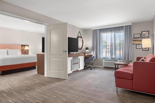a hotel room with a bed and a red couch at Hampton Inn & Suites Fresno in Fresno