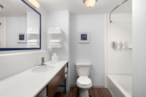 a white bathroom with a toilet and a sink at Hampton Inn & Suites Fresno in Fresno