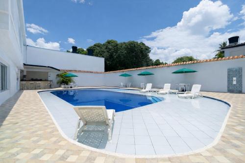 a swimming pool with chairs and umbrellas on a patio at Casa Serena Hotel Boutique in Melgar