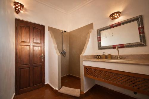 a bathroom with a sink and a mirror on the wall at Riad les trois merveilles in Essaouira