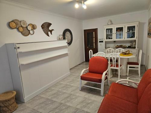 a living room with a red chair and a table at Âncora Guest House in Monte Gordo
