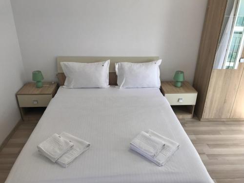 a bedroom with a large bed with two white pillows at Beach House in Mamaia Sat/Năvodari