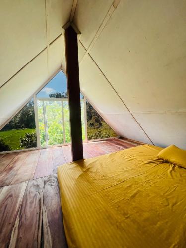 a bed in a room with a large window at Kekulama Eco Cabana Galle in Galle